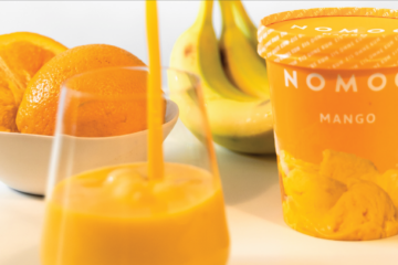Das Bild zeigt ein Nomoo-Mangoeis sowie eine Obstschale und einen Saft