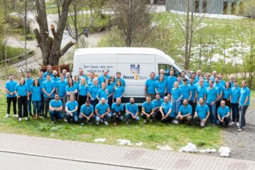 Team von Next2Sun - ca. 60 Personen im türkisblauen Polohemd vor einem Transporter mit Logo-Aufdruck