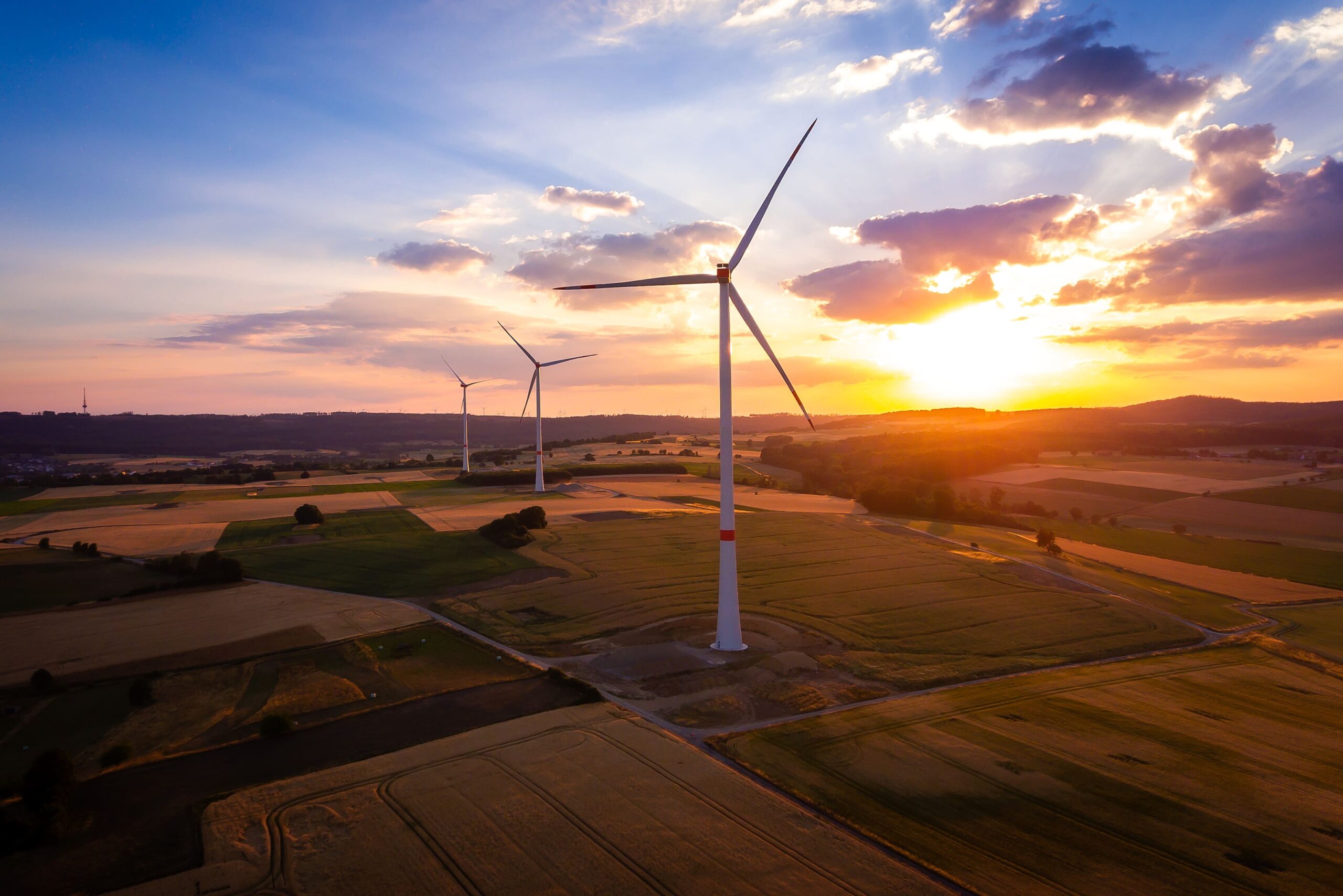 Drei Windräder der GLS Bank in der Abendsonne