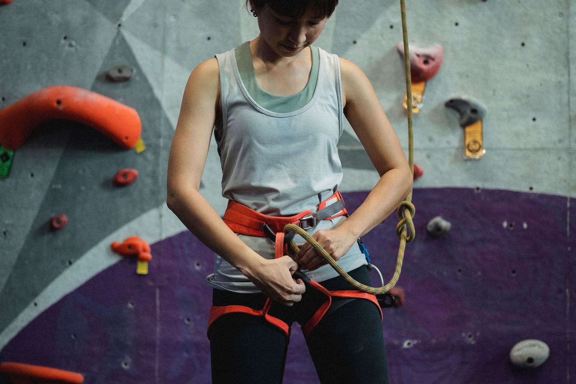 Frau mit Sicherheitsausrüstung für eine Kletterwand